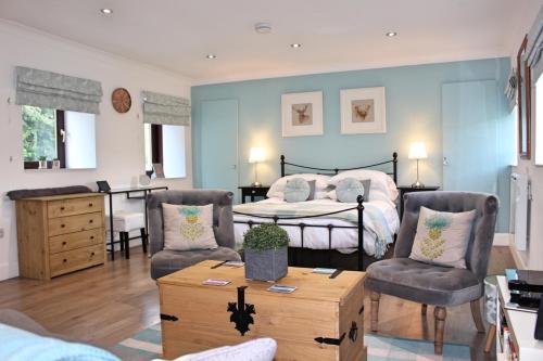 1 dormitorio con 1 cama, 2 sillas y mesa en Cobbler's Cottage en Dunblane
