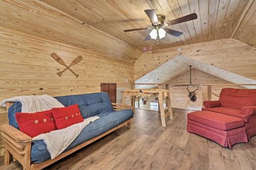 a living room with a couch and a ceiling fan at Peaceful Family Cabin on 10 Acres with Game Room! in Heflin