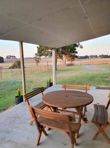 a wooden table and chairs under an umbrella at Pleasant Hill BnB in Mount Gambier