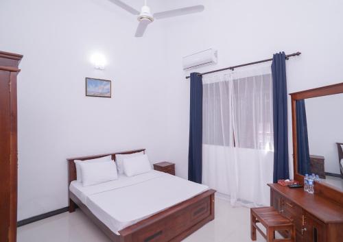 um quarto com uma cama e uma janela em StayAtRichmondHill - Free Air Conditioning WIFI em Galle