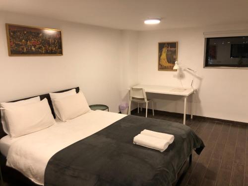 a hotel room with a bed and a desk at Hassan Guesthouse in Nazareth