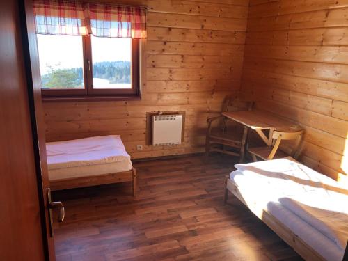 a room with two beds in a log cabin at Chaty Lipa in Levoča