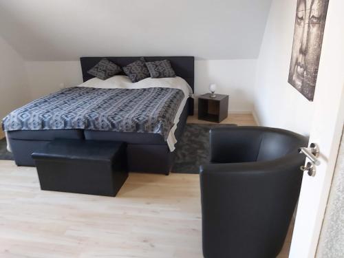伊塞爾恩哈根的住宿－Top-Apartment，一间卧室配有一张床和一张黑椅