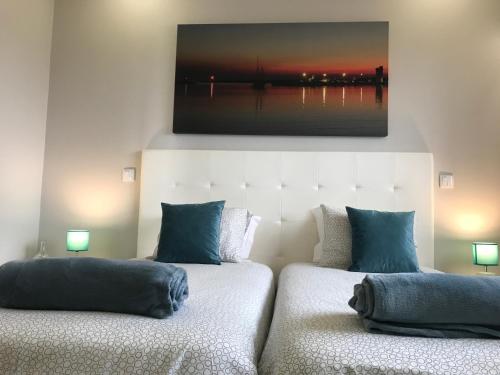 two beds in a room with a picture on the wall at Vasco da Gama in Póvoa de Varzim