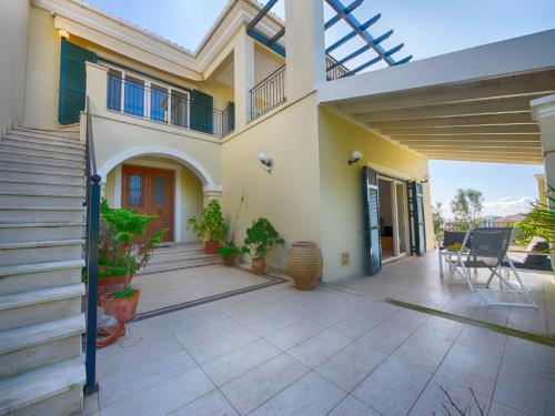 a house with a porch with a patio at Spacious 4-Bedroom Villa with Private Pool and Stunning Sunset Views, 3 Minutes from the Beach in Afionas