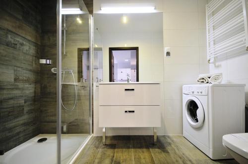 a bathroom with a washing machine and a washer at Apartament C003 Polanki Park in Kołobrzeg