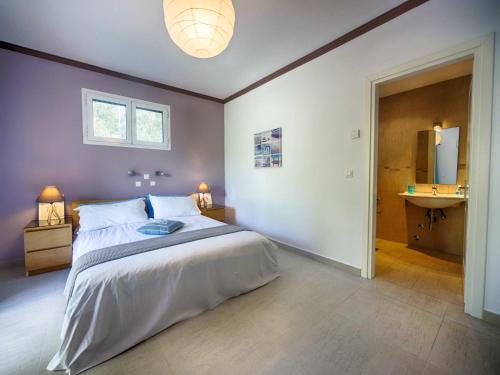 a bedroom with a large bed and a sink at Spacious 4-Bedroom Villa with Private Pool and Stunning Sunset Views, 3 Minutes from the Beach in Afionas