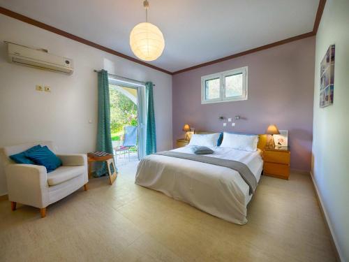a bedroom with a bed and a chair and a window at Spacious 4-Bedroom Villa with Private Pool and Stunning Sunset Views, 3 Minutes from the Beach in Afionas