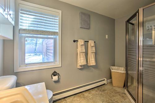 a bathroom with a shower and a sink and a window at 4 Season, Waterfront Houghton Lake House with Dock! in Houghton Lake