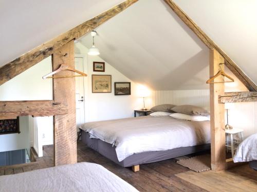 a bedroom with two beds in a attic at The Fork and Shovel Farm in Bräcke