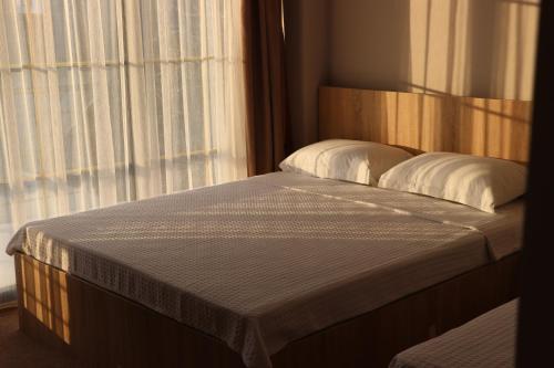 a bed with two pillows in a room with a window at Riva in K'obulet'i