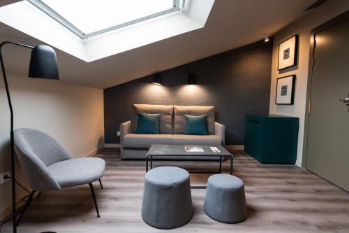 a bedroom with a bed and a table and a chair at Atenea Rekord Suites Barcelona in Barcelona