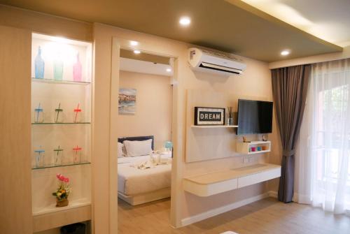 a bedroom with a bed and a tv in a room at Seven Seas Pattaya Poolside Room ห้องติดสระ in Jomtien Beach