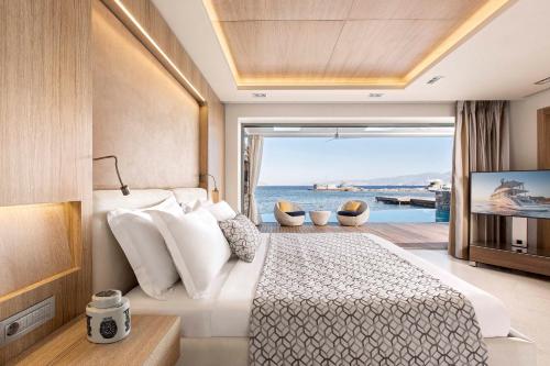 Schlafzimmer mit einem großen Bett und Meerblick in der Unterkunft Elounda Beach Hotel & Villas, a Member of the Leading Hotels of the World in Elounda