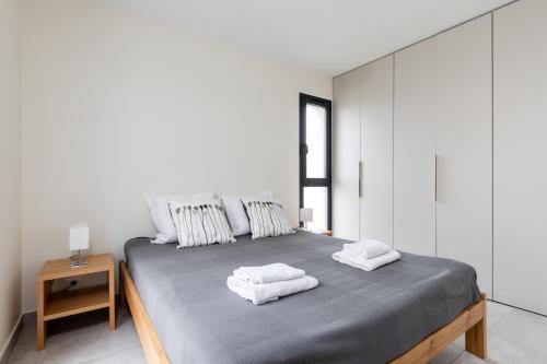 a bedroom with a large bed with towels on it at Les Cyclistes - Apartment i in Malaucène