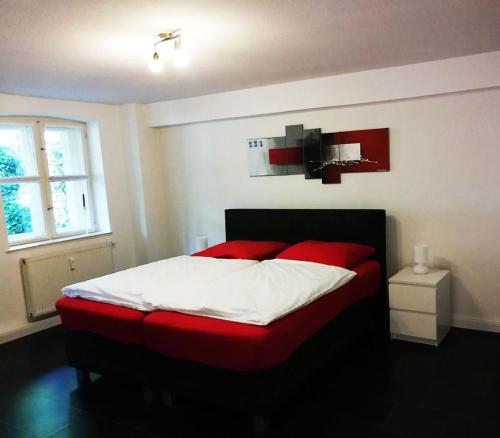 een slaapkamer met een groot bed met rode kussens bij Halbe Treppe in Potsdam