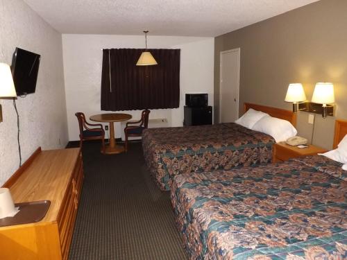 a hotel room with two beds and a table at KCI Lodge in Kansas City