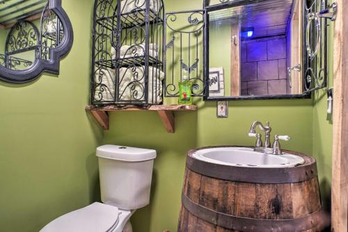 La salle de bains est pourvue de toilettes, d'un lavabo et d'un miroir. dans l'établissement The Treehouse Cabin Creekside Home with Hot Tub!, à Summerville