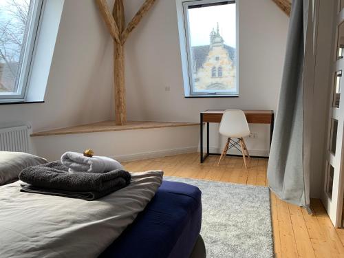 Schlafzimmer mit einem Bett, einem Schreibtisch und Fenstern in der Unterkunft Villa am Wall in Osnabrück