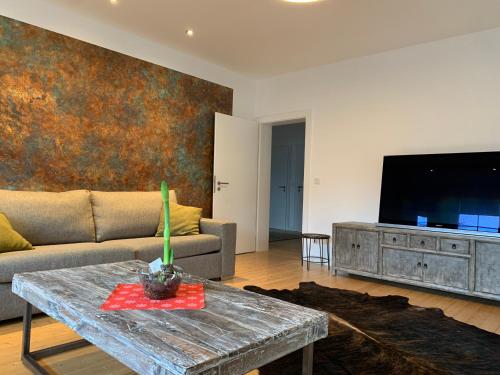 a living room with a couch and a tv at Villa am Wall in Osnabrück