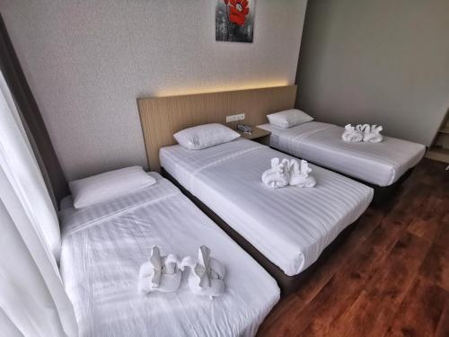a room with two beds with toy rabbits on them at Green World Hotel in Semporna