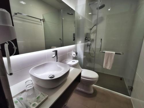 a bathroom with a sink and a toilet and a shower at Green World Hotel in Semporna