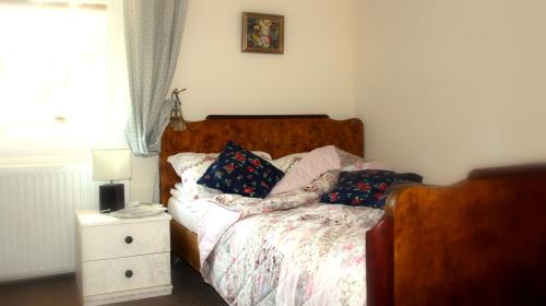 ein Schlafzimmer mit einem Bett mit Kissen und einem Nachttisch in der Unterkunft Pokój Pod Kluczem in Wolimierz