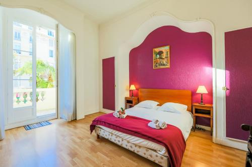 - une chambre avec un grand lit et un mur pourpre dans l'établissement VIA ITALIA AP1054 - By Riviera Holiday Homes, à Nice