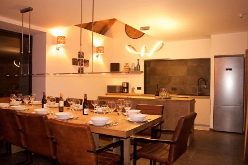 a dining room table with chairs and wine glasses at Chalet Le Petit Plus in Vaujany