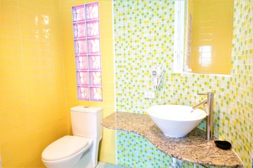 墾丁的住宿－遇見墾丁 ，黄色的浴室设有水槽和卫生间