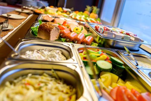 a buffet with many trays of food on a table at Altstadthotel Am Theater in Cottbus