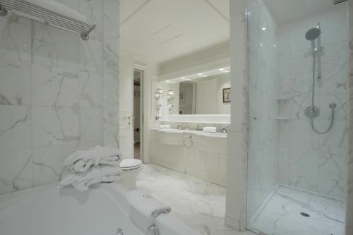 a bathroom with a tub and a toilet and a shower at Grand Hôtel des Alpes in Chamonix-Mont-Blanc