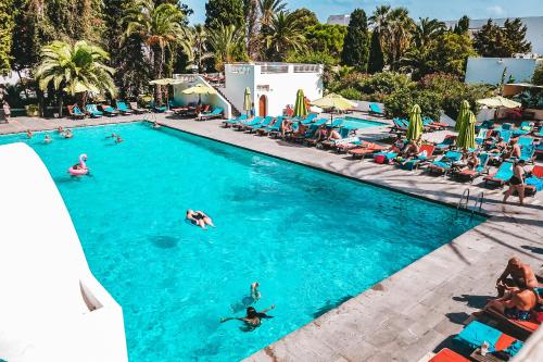 een groep mensen die zwemmen in een zwembad bij The Orangers Beach Resort and Bungalows All Inclusive in Hammamet
