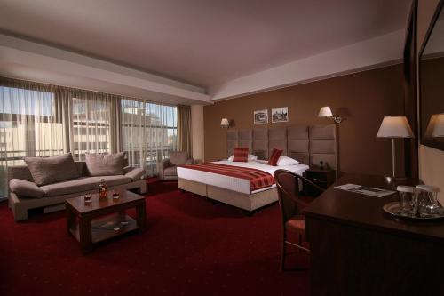 a hotel room with a bed and a couch at Reghina Blue Hotel in Timişoara