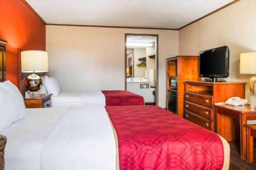 a hotel room with two beds and a flat screen tv at Econo Lodge in Norwalk