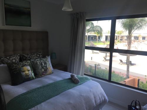 a bedroom with a bed and a large window at The Blyde - Beachfront in Pretoria