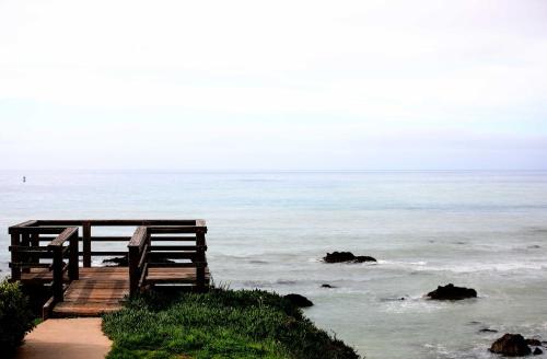 a wooden boardwalk leading to the ocean with rocks at 3 Mi to Golf and Wineries Arroyo Grande Home! in Arroyo Grande