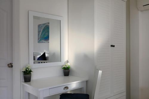 a bathroom with a white vanity and a mirror at Kata White Villas in Kata Beach