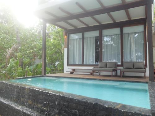 a swimming pool with two chairs and a house at L'Osteria Luxe Beachfront B&B in General Luna