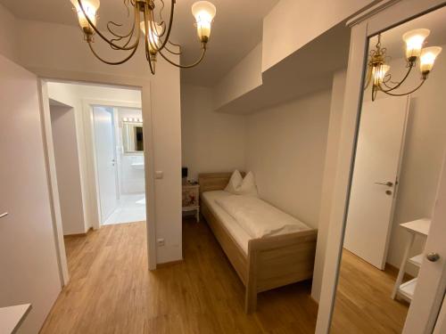 een kleine kamer met een bed en een spiegel bij Ferienapartement Liebling in Vöcklabruck