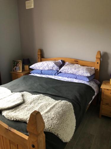 a bedroom with a bed with a wooden headboard and pillows at The Collins,Our View from The Top in Listowel