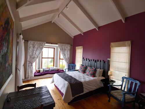 a bedroom with purple walls and a bed and a table at Happy Homes - Imhoffs Gift in Imhoffʼs Gift