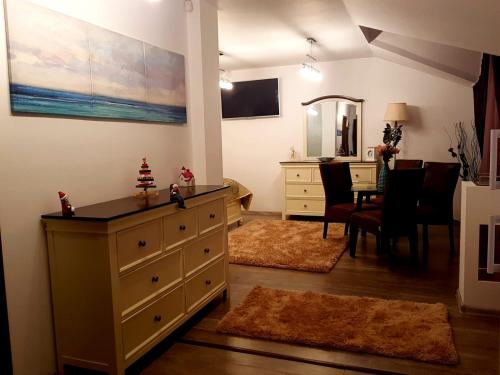 a living room with a dresser and a dining room at Apartament Fluturaș de Stâncă Comarnic in Comarnic