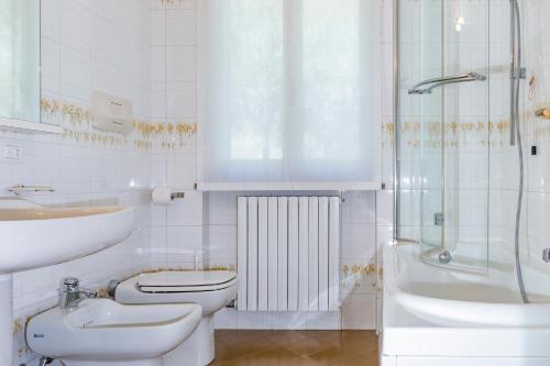 La salle de bains est pourvue de toilettes, d'un lavabo et d'une douche. dans l'établissement IseoLakeRental - Vacanza Romantica, à Riva di Solto