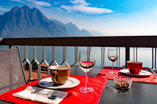 a table with two glasses of wine on a balcony at IseoLakeRental - Vacanza Romantica in Riva di Solto