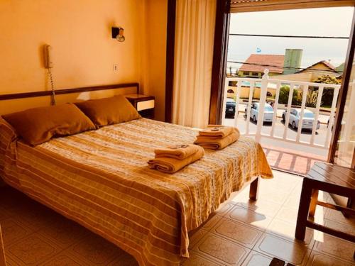 阿肖海Hotel Scoglie的卧室里有一张床，床上放着两条毛巾。