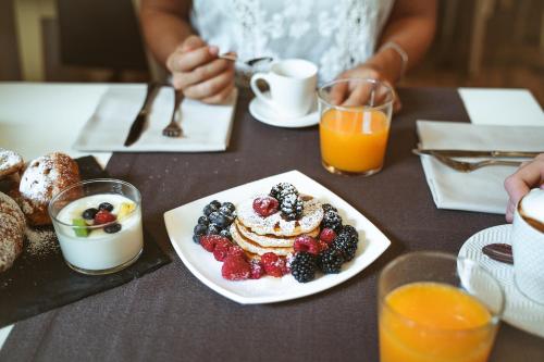 a table with a plate of pancakes and fruit at Bonotto Hotel Belvedere in Bassano del Grappa