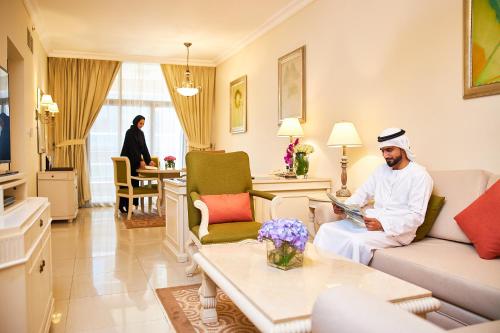 a man is sitting in a living room at Mercure Hotel Apartments Dubai Barsha Heights in Dubai