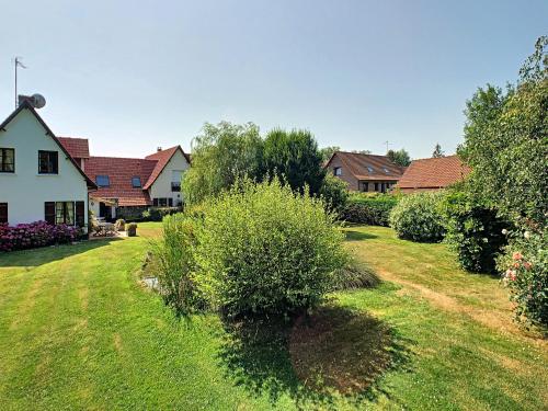 un groupe de maisons dans une cour avec une pelouse dans l'établissement Le Clos de l’Ermitage, à Saint-Josse