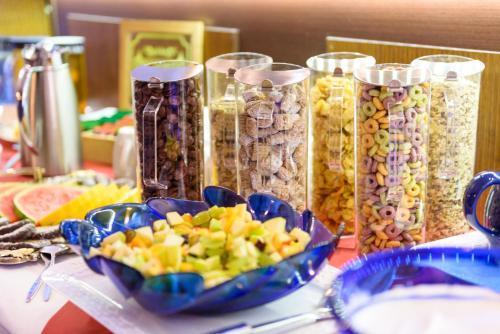 a table topped with glass containers filled with different types of food at Altstadthotel Am Theater in Cottbus